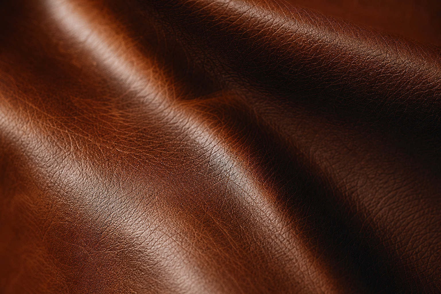 Gros plan sur la texture d'un cuir lisse brun avec reflets, montrant le grain naturel