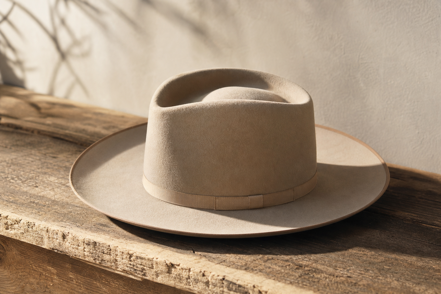 Chapeau Stetson beige à large bord posé sur une surface en bois vieilli