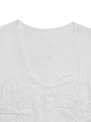 Vit crêppad blus med blommiga applikationer